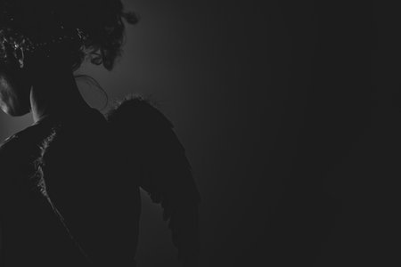 Woman angel with wings and curly hair in the dark, angelの写真素材