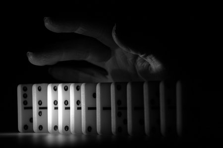 Female hand and dominoes on the table in the dark black and white photo, dominoesの写真素材