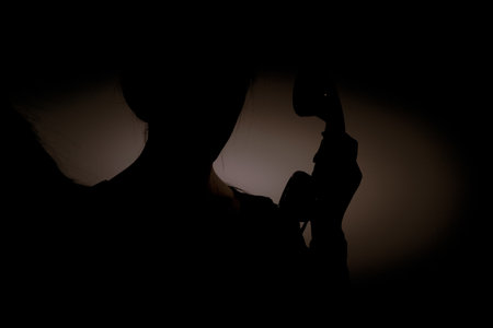 The girl calls in the dark on an old phone, calls, talking on the phone, fear and lonelinessの写真素材