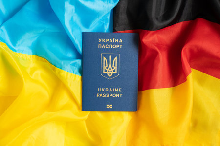Flag of Ukraine and Germany in the middle lies Foreign biometric passport of a Ukrainian, migrateの写真素材