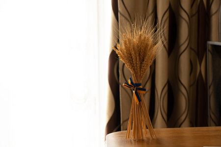 Spikelets of wheat, tied with a ribbon of the color of the Ukrainian flag, stand on the table in the Ukrainian House, the flag of Ukraine, stop the warの写真素材