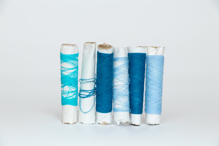 Blue threads of different shades on a spool on a white isolated background, fashion and trendの写真素材
