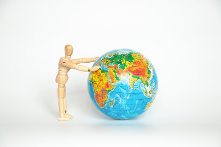 Globe and a wooden man holding a globe on a white background close-up