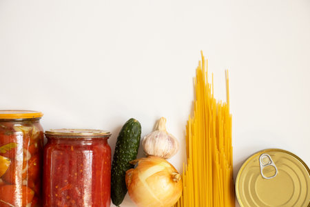 Tomatoes and spaghetti and cucumber with garlic and canned food on a white background, grocery setの写真素材