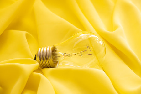 An incandescent lamp lies on a yellow clothの写真素材