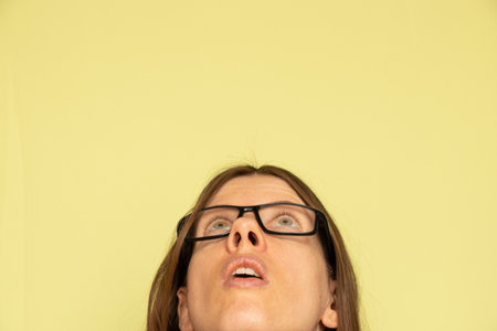 Portrait of a girl who thinks on a yellow backgroundの写真素材