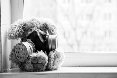 Soft baby bunny in a gas mask sits on the window in the house, gas attackの写真素材
