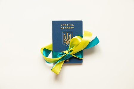 Foreign biometric passport tied with a ribbon from the flag of Ukraine on a white backgroundの写真素材