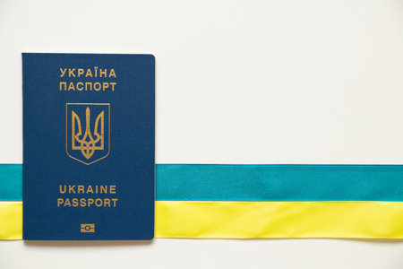 Foreign biometric passport and tape lie horizontally in the colors of the flag of Ukraine on a white background, passportの写真素材
