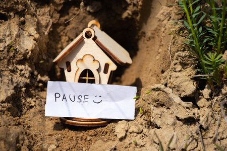 a wooden house stands on the ground in the sun and next to it is an inscription in English pauseの写真素材
