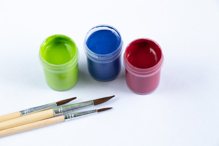 watercolor paints and brushes on the table in daylightの写真素材
