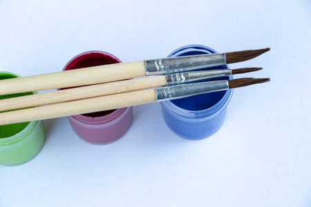 watercolor paints and brushes on the table in daylightの写真素材