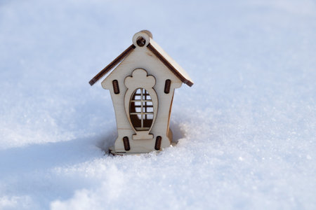 children's little wooden house stands on the snow in the afternoon on the streetの写真素材