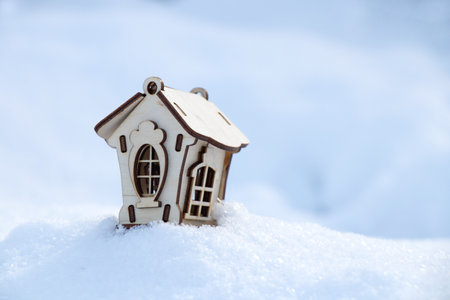children's little wooden house stands on the snow in the afternoon on the streetの写真素材