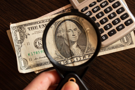 dollars and magnifying glass on the table, economy and financial debtの写真素材
