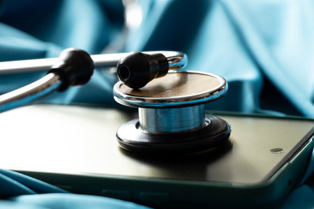 A stethoscope lies on a smartphone on a blue background, online doctor, doctor callの写真素材