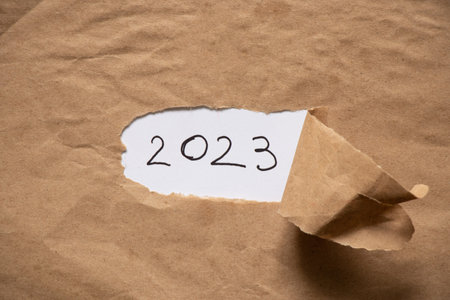 Brown paper with a hole in the middle and text 2023, happy new yearの写真素材