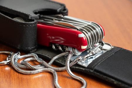 Multifunctional knife on a wooden table black leather case