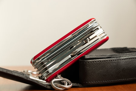 Multifunctional knife on a wooden table black leather caseの写真素材