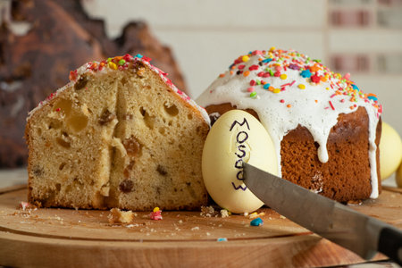 Festive Easter cake and a painted egg with the text Moscow pierced with a knife on the table at home...