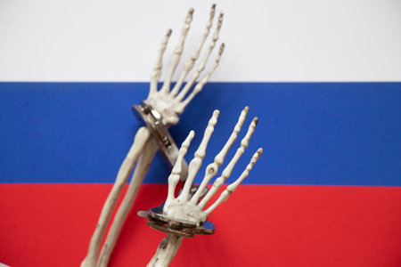 Skeleton hands in handcuffs on the flags of Russia, law and justiceの写真素材