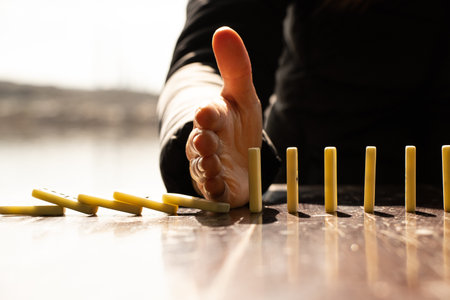 Women's hand and dominoes on a wooden table in the sun in the parksの写真素材