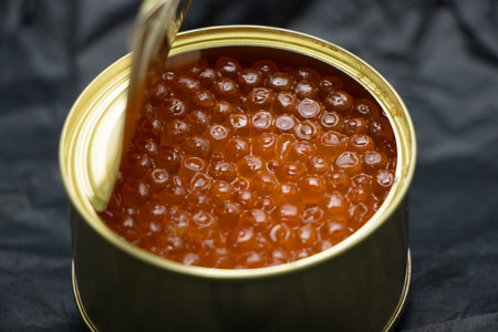 iron can with red caviar on isolated background close up