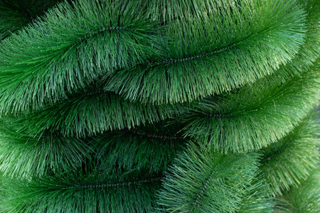branches of a green artificial Christmas tree as a background close-up, Christmas decor