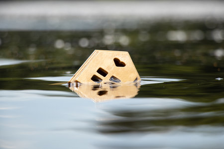 A small wooden house floats on the Dnieper River in Ukraine in the sunの写真素材