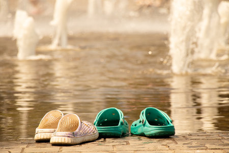 Rubber slippers stand near the city pool in the summer in Ukraine in the city of Dnipro when...