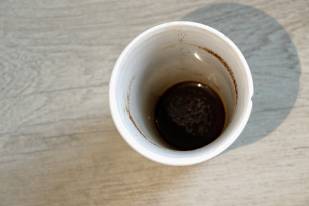an empty dirty coffee cup stands on a wooden tableの写真素材
