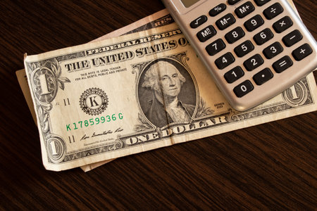 dollars and magnifying glass on the table, economy and financial debtの写真素材