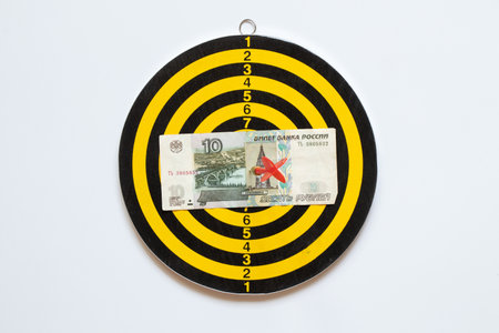 Ten rubles in the center of the board darts and drotin on a white background, right on target, business and defaultの写真素材