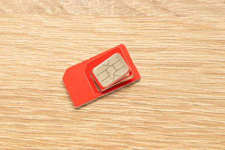 sim card of red color on an isolated background close-up
