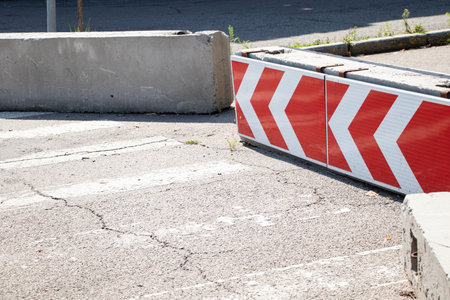 Warning road sign turn direction in the city on a concrete block on the road in Ukraine, turn direction signの写真素材