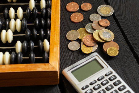 Calculator and nearby are bills and coins on the table, finance and businessの写真素材