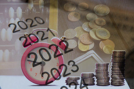 List of 2022 and 2023 on paper against the background of coins, calculator and bills on the table, business and finance in the yearの写真素材