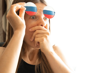 Flag of Russia on the glasses of a girl, blind and deceived by Russian propaganda, sees nothing because of propagandaの写真素材