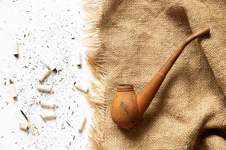 Smoking pipe, cigarette and ashes scattered around lie on the table close-upの写真素材