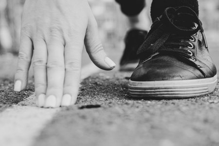 Hands and feet of a runner in sneakers on the starting line at the stadium in the courtyard in the city of Dniproの写真素材