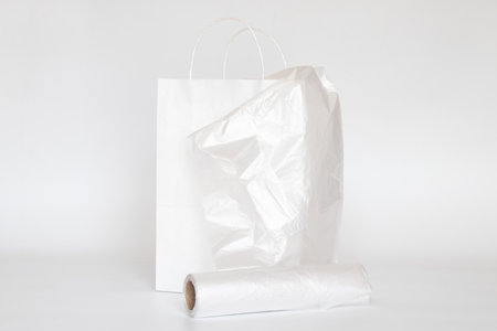 White paper bag and plastic transparent bag on a white backgroundの写真素材