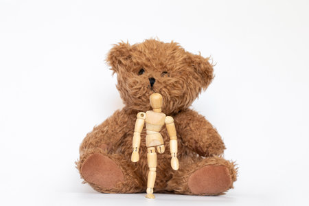Wooden man without a leg and a bear on a white background, children's toysの写真素材