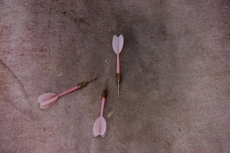 Old dirty rusty darts lie on pink cloth