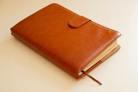 Brown leather notepad lies on a light table in the light,work notebook