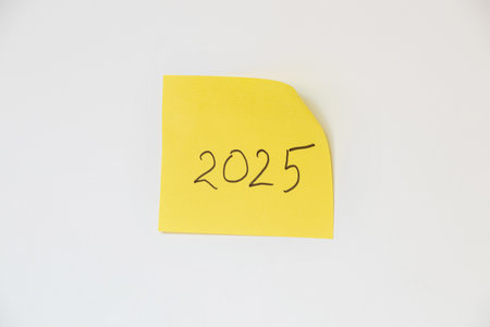 2025 handwritten on a yellow piece of paper on a white backgroundの写真素材