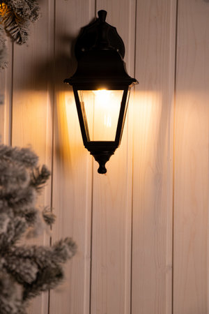 Street lamp on the facade of a wooden house and a branch of a New Year tree, New Yearsの写真素材