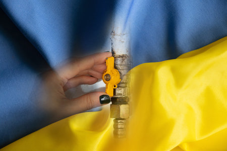 A woman's hand closes a gas tapの写真素材