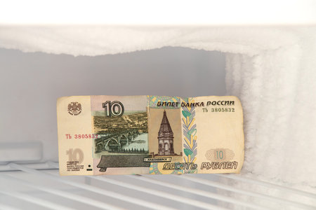 A 10 Russian ruble banknote lies in a freezer in ice, freezing of Russian money, sanctions and blocking of assetsの写真素材
