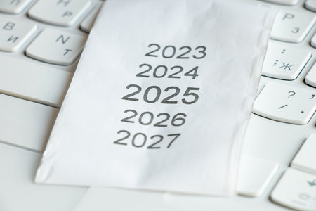 List of years from 2023 to 2027 on a cash register receipt on a white keyboard, year 2025 on the...