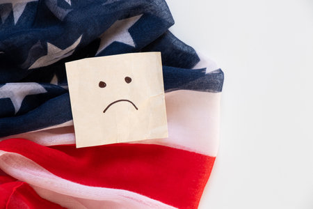 American flag and paper card with a drawing of emotions of sadness close-upの写真素材
